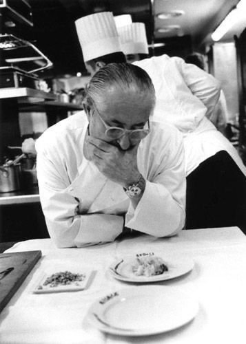 Chef carefully reviewing a finished plate