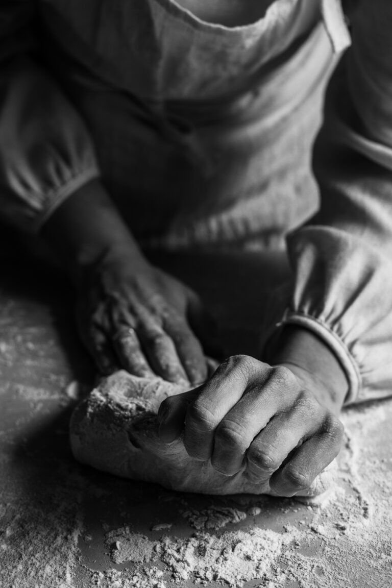 Baker shaping fresh dough by hand