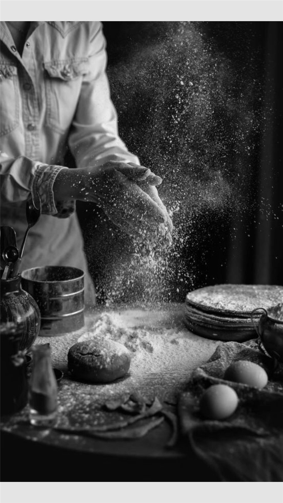 Chef dusting flour across a preparation table